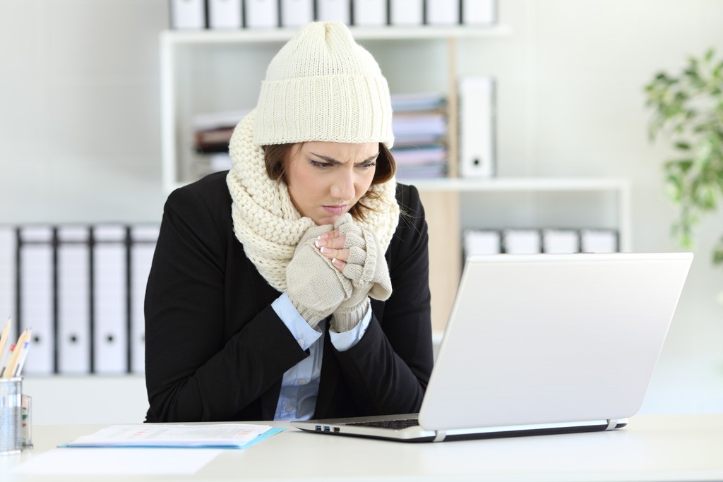 Cold office worker wearing a hat and scarf
